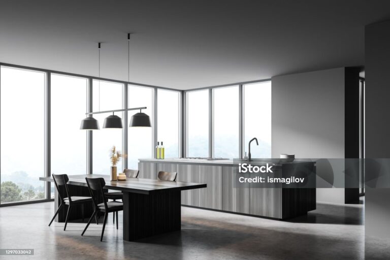 Corner of panoramic kitchen with gray walls, concrete floor, wooden island and dining table. 3d rendering